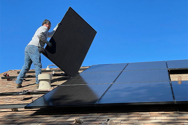 Imagen de una persona instalando placas solares en una vivienda