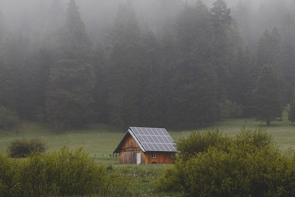 Imagen de una casa en el campo con placas solares