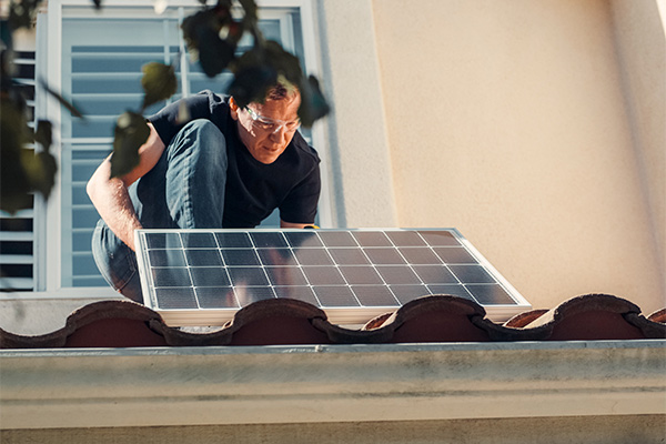 Imagen de una persona instalando en una vivienda placas solares