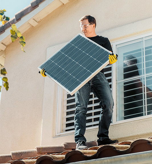 Imagen de una persona instalando placas solares en un casa